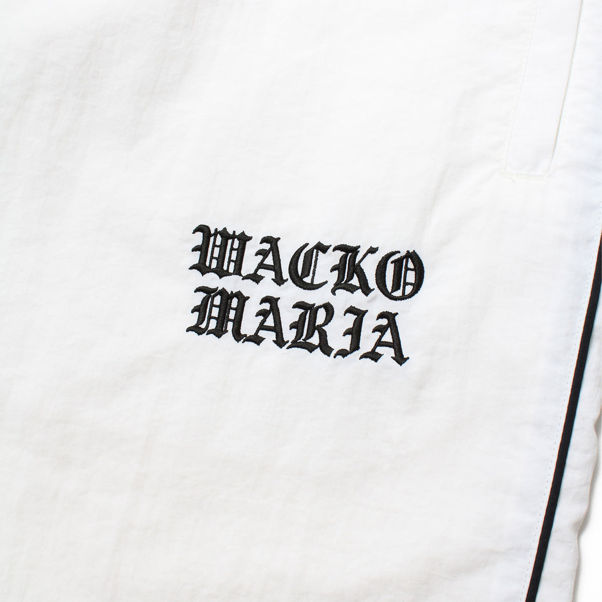 WACKO MARIA(ワコマリア)2026年秋冬先行コレクションから、TRACK PANTS (TYPE-3) 26FWE-WMO-TP03 左ももWACKO MARIAのロゴ刺繍