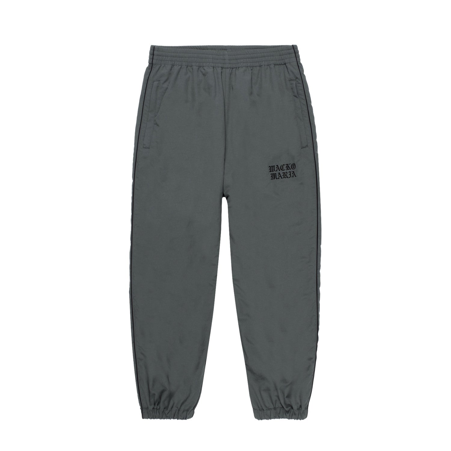 WACKO MARIA（ワコマリア）2025年秋冬コレクション「天国東京」から、NYLON TRACK PANTS (TYPE-2) 25FW-WMO-TP05のグレーを入荷致しました。

グレーのナイロン生地をベースに、サイドにブラックのパイピング。
ウエストはゴムとドローストリングで調整できます。
裾はゴムとファスナー付き。
左ももに「WACKO MARIA」のロゴ刺繍。